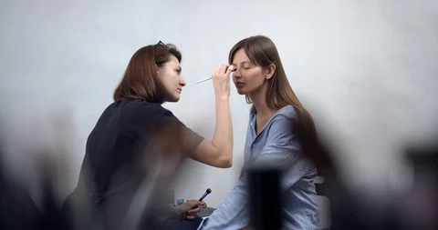 Visagiste applying makeup on models face Stock Footage 126354159