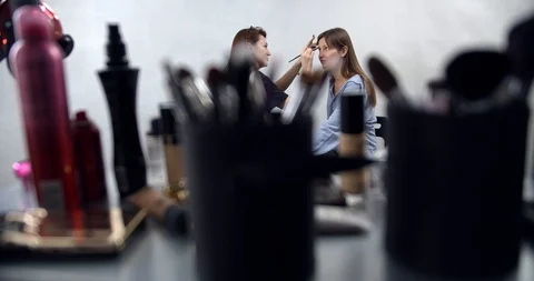 Visagiste applying makeup on models face Stock Footage 126354244