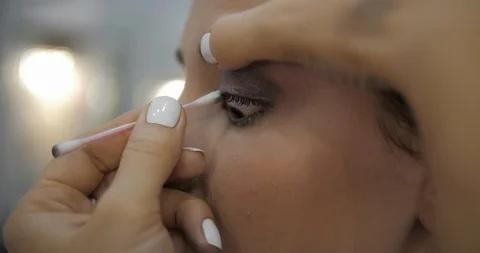 Visagiste cleans model eyebrow from eyeshadows closeup Stock Footage 124257995