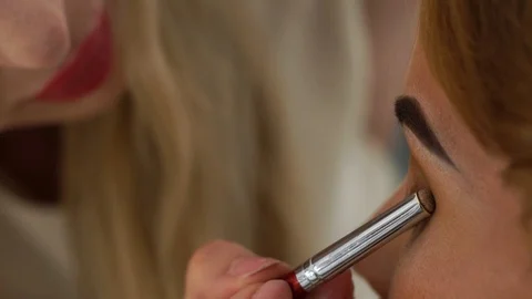Visagiste using eye shadow brush for application eyes makeup. Face young woman Stock Footage 91474905