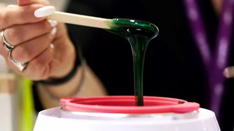 Viscous green sugaring paste for depilation drips from the end of wooden stick Stock Footage 257251118