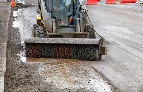 Viscous mud in front of a compact tractor with a nylon hydraulic brush on a c 스톡 사진