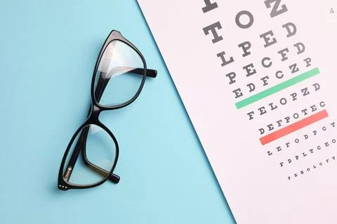 Vision correction glasses on the background of a vision test table with space Stock Photos