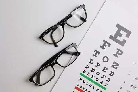 Vision correction glasses on the background of a vision test table with space Stock Photos