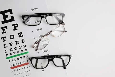 Vision correction glasses on the background of a vision test table with space Foto stock