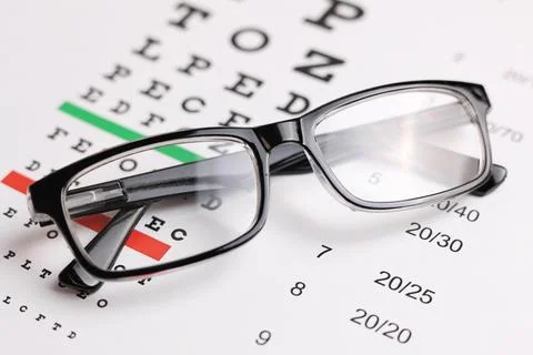 Vision correction glasses on the background of a vision test table with space Foto stock