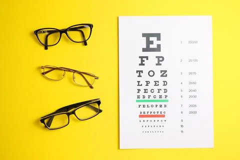 Vision test table and glasses with a colored background. Stock Photos