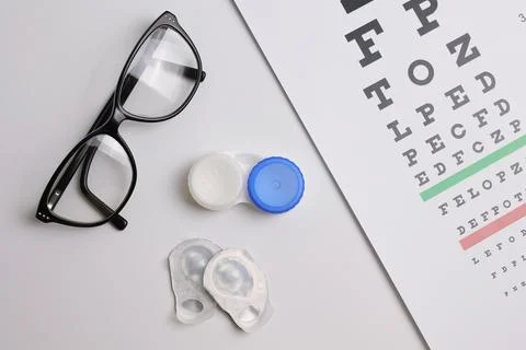 Vision test table, glasses and contact lenses on a white background. Foto stock