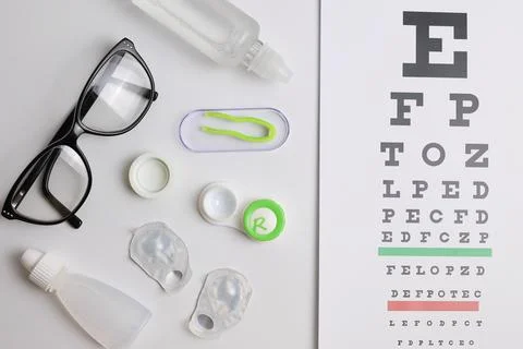 Vision test table, glasses and contact lenses on a white background. Foto stock