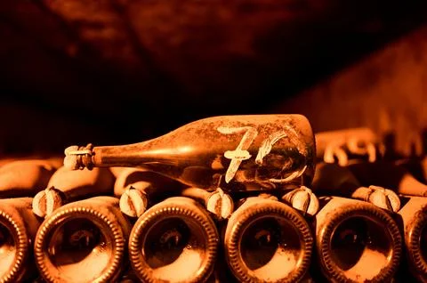 Visit of deep and long underground caves with dusty bottles on racks, tradi.. Stock Photos