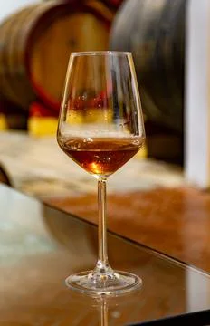 Visit of wine cellar with old large oak barrels, glass of fortified dry or .. Stock Photos