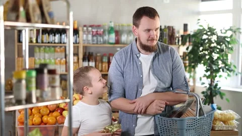 Visiting store, father and son is looking at something on shelf of showcase. Stock Footage 341784584