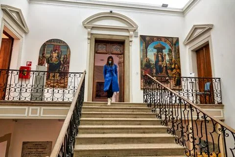Visitor in blue coat walking down the stairs of the museum Stock Photos