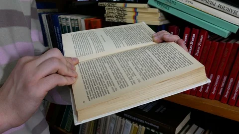 Visitor carefully reads a book in the library Stock Footage 86565751