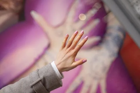 Visitor examines intricate henna patterns on hand with jewelry in city setting Stock Photos