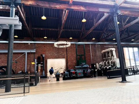 Visitor exploring industrial engine exhibition in a historic Manchester, UK.. 스톡 사진