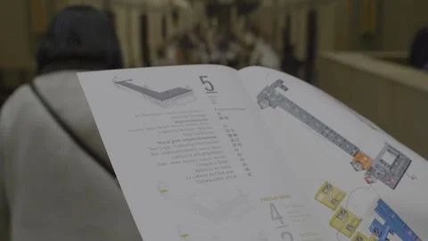 Visitor holding a map of Musée d'Orsay layout while exploring the museum Stock Footage 305469727