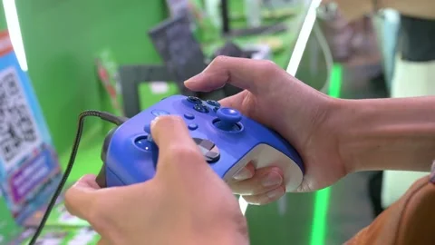 A visitor plays a videogame using a controller from the American video Stock Footage 209951365
