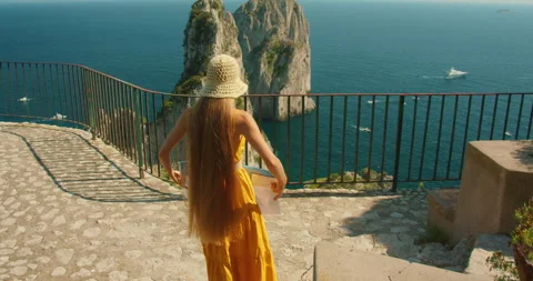 Visitor reading map on Capri lookout terrace above Faraglioni sea stacks on Stock Footage 343249705
