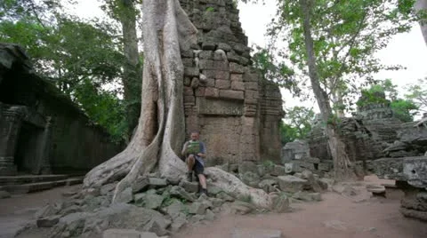 Visitor reading tourist information map in Ta Prohm temple, angkor Stock Footage 12172129