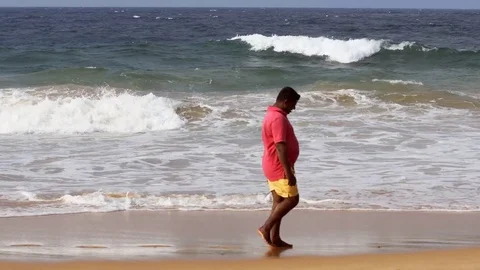 Visitor strolling along a popular beach in Hikkaduwa. Video 4k UltraHD Stock Footage 77373150