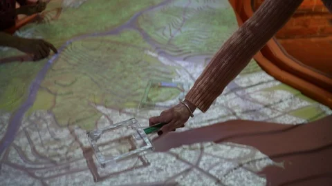 Visitor tries educational geographical multimedia table in Science museum Stock Footage 90003393
