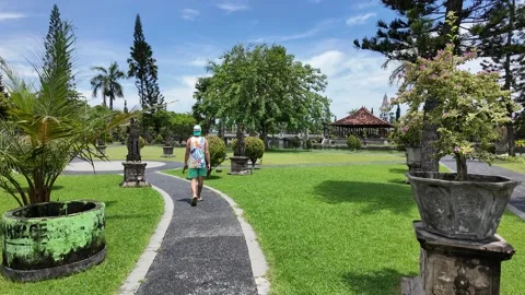 Visitor Walking Along a Tropical Bali Garden Path Vidéo 347591663
