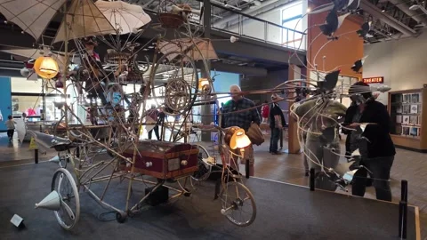 Visitors admire a complex steampunk sculpture in a museum gallery. Stock Footage 345618971