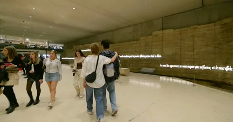 Visitors admiring the wall of text by Philip K. Dick at the Musee de la Musique Stock Footage 312035736