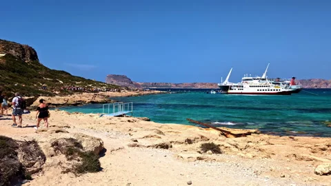 Visitors arrive at Balos beach lagoon with turquoise shallow water, white sand Stock Footage 345666692