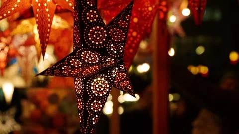 Visitors browsing glowing star lanterns in vivid red, orange, gold, pink at.. Video stock 322772887