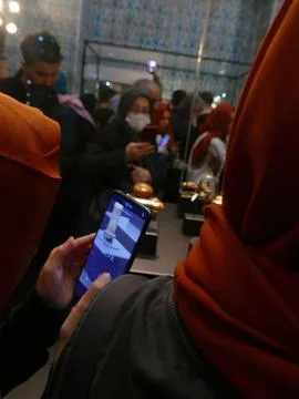Visitors capturing ancient relics at Topkapi Palace, using smartphones for .. Stock Photos