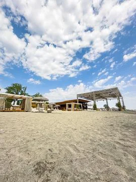 Visitors enjoy a beachside area with seating and structures for shade. The sa Photos