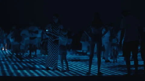Visitors Enjoy Greeting to the Sun Light Installation at Night 스톡 동영상 340451761
