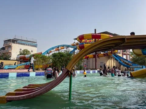 Visitors Enjoying Wave Pool Activities Beneath Colorful Water Slides at Wat.. 스톡 사진