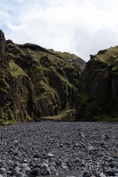 Visitors Explore Moss Covered Cliffs and Rocky Riverbed in Iceland Stock Photos