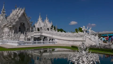 Visitors explore the stunning white Wat Rong Khun temple Stock Footage 310795641