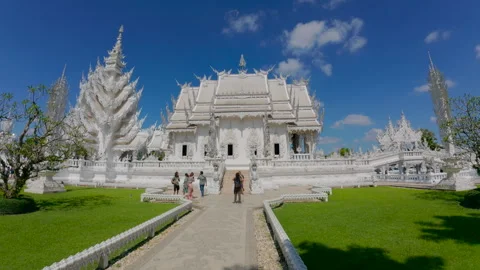 Visitors explore the stunning white Wat Rong Khun temple Video stock 310796359