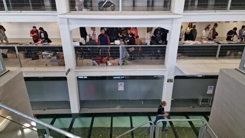 Visitors exploring a bustling comic book convention with books on display in Stock Footage 294337595