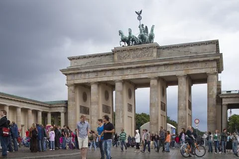 Visitors Exploring the Iconic Brandenburg Gate in Berlin on a Cloudy Day Stock Photos