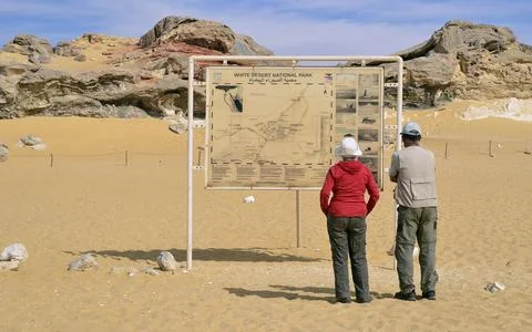Visitors exploring map in Qattara desert area Stock Photos