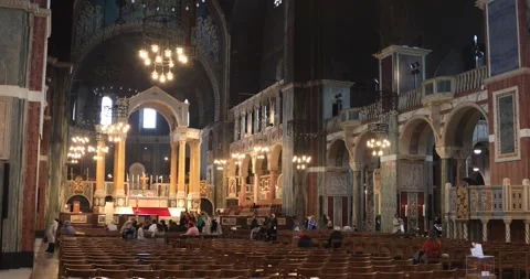 Visitors inside Westminster Cathedral facing the glowing altar in London Stock Footage 321016220