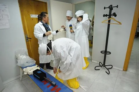 Visitors put protective clothes on to pass to the building of the Chernobyl.. Stock Photos