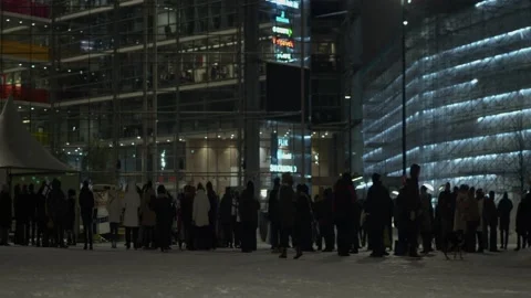 Visitors queue on snowy winter night street for LUX Helsinki event Stock Footage 198886574