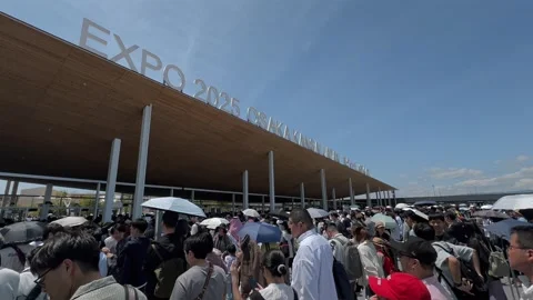 Visitors Queue Under the Summer Sun at the Entrance of Expo 2025 Osaka Stock Footage 321339427