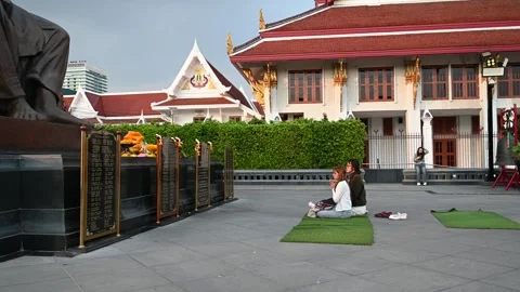 Visitors sit beside offerings at Somdet To Memorial Vidéo 338385230