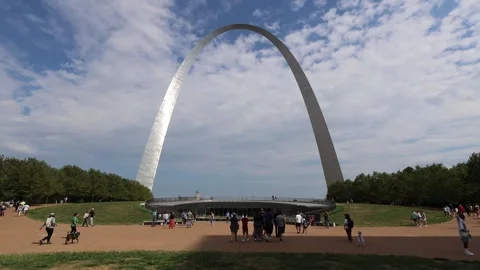 Visitors stroll across the grounds of the Gateway Arch under a partly cloud.. Stock Footage 339246508