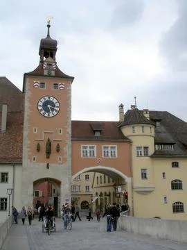 Visitors Stroll Across the Old Stone Bridge, Admiring the Historic Clock To.. Stock Photos