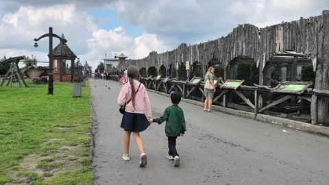 Visitors stroll along a pathway at an outdoor historical site during a cloudy da Stock Footage 340357237