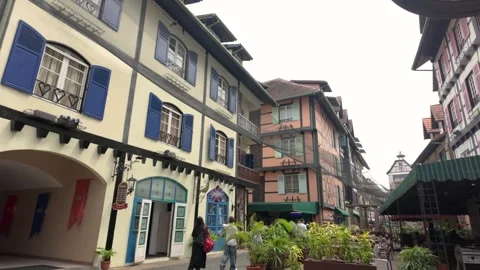 Visitors stroll through the charming streets of Bukit Tinggi French Village Stock Footage 337977665